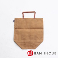 卡其色麻布材質的提把式收納袋，袋身有明顯的織紋，提把為紅白條紋織帶。