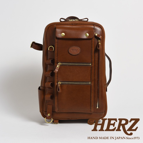 棕色皮革製成的多功能後背包，具有多個拉鍊口袋、皮革標誌和金屬配件。