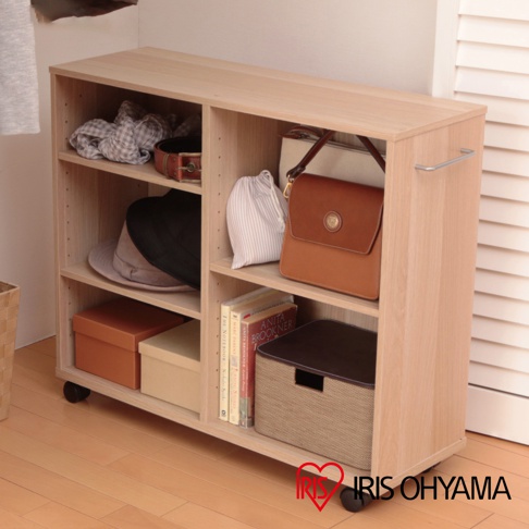 淺木紋色開放式收納推車，寬60公分，配有三個開放式層架，上面擺放著衣物、帽子、包包、書籍及收納盒，底部裝有四個輪子，側邊附有金屬拉桿。