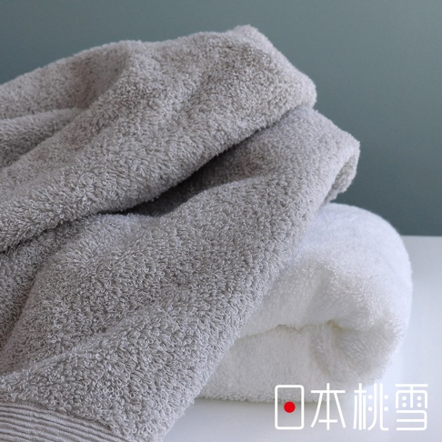 堆疊的 Sensui Yu 精梳棉毛巾，上層為淺灰色，下層為白色，材質觸感柔軟蓬鬆。