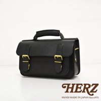 黑色皮革迷你肩背包，配有雙金屬扣帶和提把，可兩用。