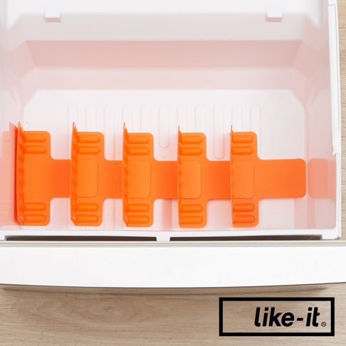 白色冷凍庫內，一個橘色的塑膠分層隔板，由左至右有四個可調節的隔間，每個隔間有三個直條紋的設計，用於整理冷凍庫內的物品。