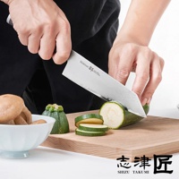 Shikisai Miyako 文化刀，刀身採用不銹鋼材質，帶有鍛造紋理。刀刃正在切割綠色櫛瓜，旁邊擺放著碗裝的香菇和切片的櫛瓜。