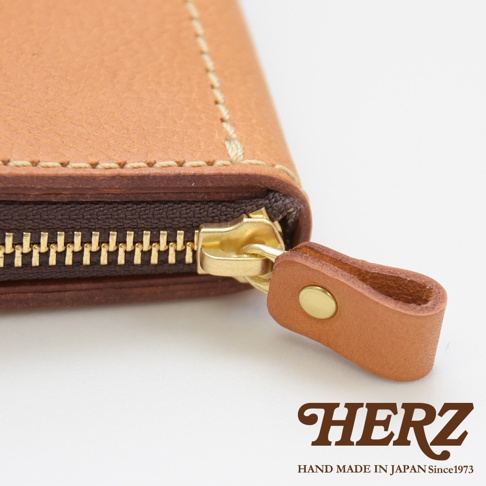 職人手作皮革經典拉鍊長夾WL-58，特寫展示淺棕色皮革、咖啡色拉鍊與金色拉頭。皮革表面紋理清晰，縫線精緻，搭配簡約的同色系皮革拉環，展現高品質的職人質感。