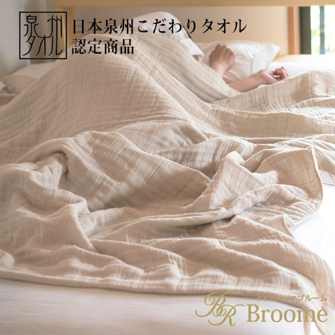 淺米色四層紗毛巾毯，材質輕盈，觸感柔軟，覆蓋在床上，部分露出一人手臂。