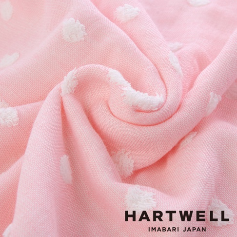 粉紅色今治純棉點點紗布浴巾，布料柔軟，帶有白色絨毛點點圖案，質感細膩，邊緣有白色紗線裝飾。