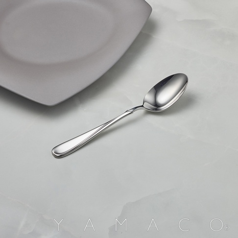 Flora系列不鏽鋼湯匙，銀色，湯匙造型優雅，上方擺放著灰色盤子，背景為白色大理石紋桌面