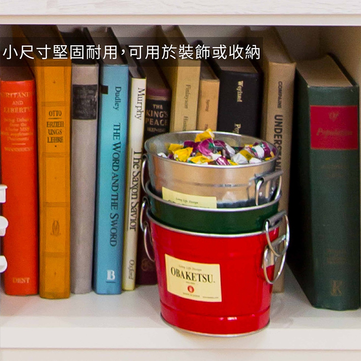 一排書架上有幾個不同顏色的儲物桶，其中紅色桶上印有OBAKETSU字樣