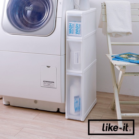 白色三層夾縫收納櫃，頂部兩抽屜內有印有「WASH」字樣的藍色標籤，下方抽屜內可見洗滌劑瓶。