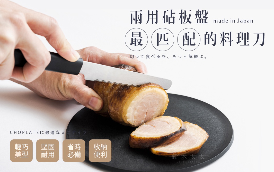 一隻手正拿著一把黑色手柄的鋸齒狀刀刃，正在切割一塊烤肉，烤肉放在一個黑色圓形盤子上。