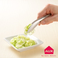 一只手正使用不鏽鋼材質的leye 不沾桌配料專用夾，夾起一小撮切好的蔥段，要放入裝有大量蔥段的白色方形盤中。