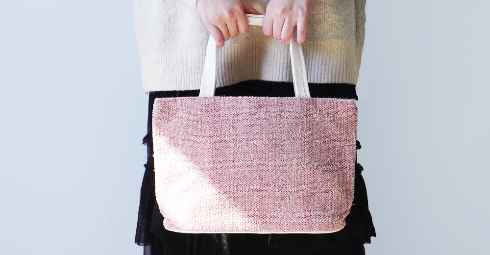 BAN INOUE 蚊帳棉裂織手提袋，粉紅色織紋，由雙手握持白色提把