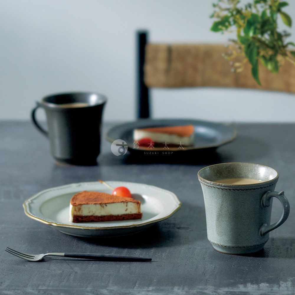 日式風格餐桌上，兩塊起司蛋糕，搭配兩杯咖啡，以及精緻的餐具，營造出悠閒的下午茶時光。