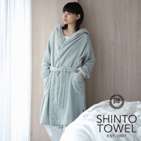 一位女性穿著淺藍色蓬鬆連帽浴袍，腰間繫著同色系腰帶，浴袍上有兩個大口袋。