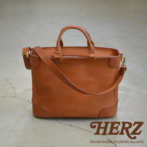 職人手作皮革Organ兩用商務托特包，採用棕色皮革製成，設有頂部提把及可拆卸肩帶，簡約實用的設計適合商務場合。