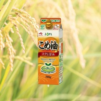 米糠玄米油 700g 產品包裝，以黃色和白色為主，印有日文說明及稻穗圖案，背景為模糊的稻田景觀。