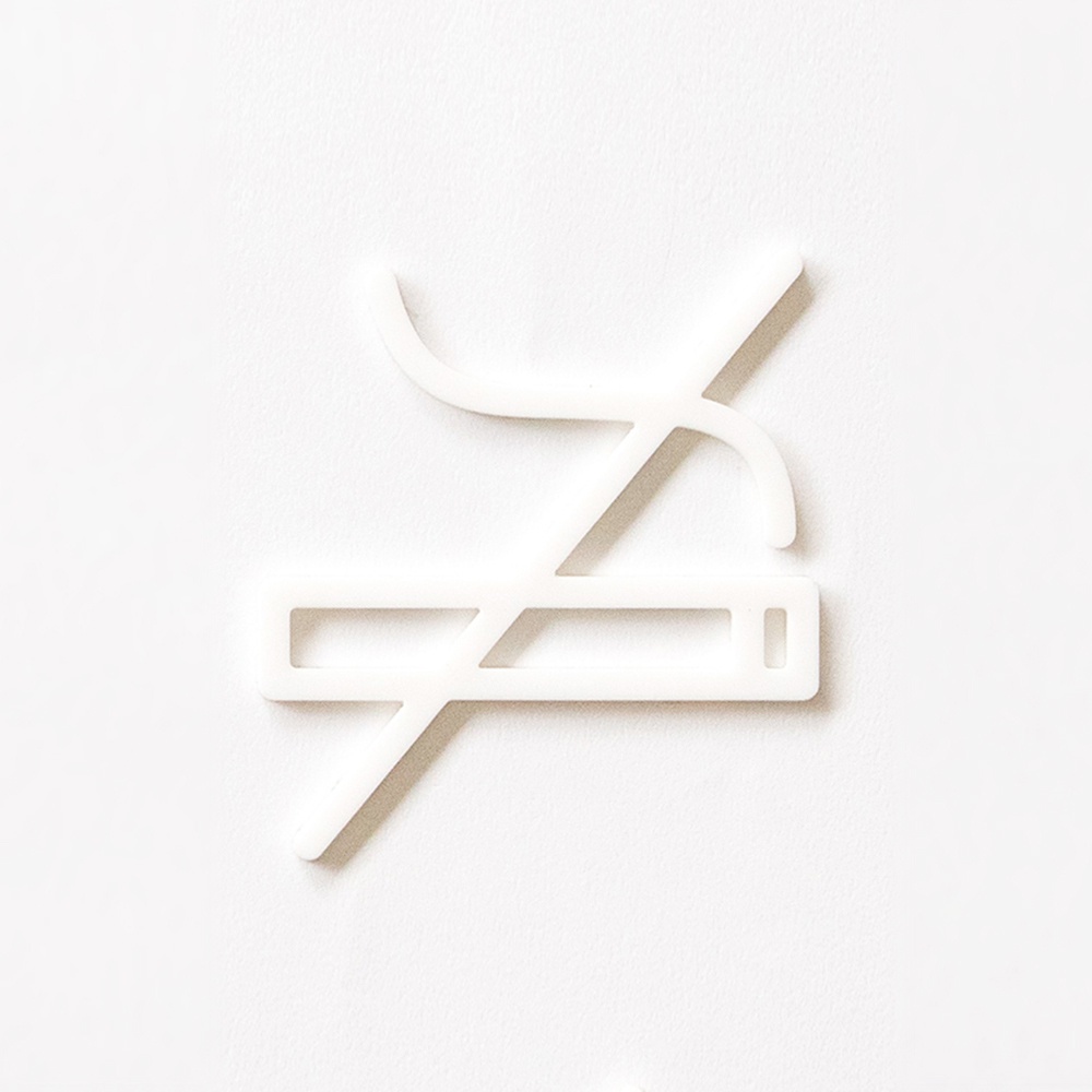 白色壓克力材質的禁煙標示牌，以簡潔的線條勾勒出禁止吸煙的符號。