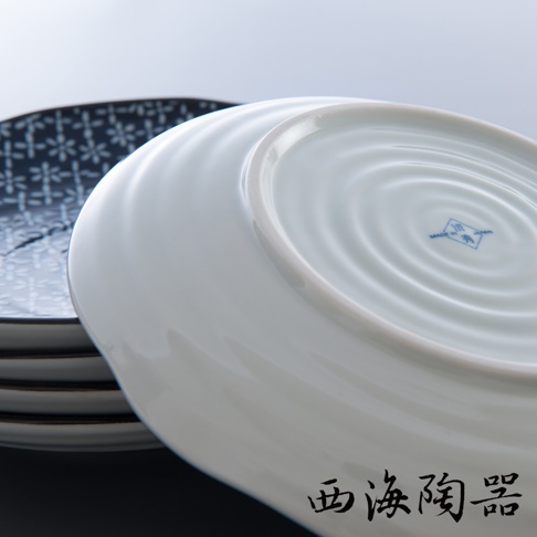日本製美濃燒白色輕量圓盤，盤底有同心圓紋路和藍色方形印記，下方疊放著印有藍色花紋的盤子。