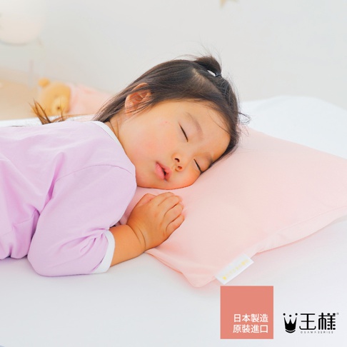 粉紅色兒童枕頭，柔軟材質，適合嬰幼兒睡眠，枕頭上印有品牌標誌。
