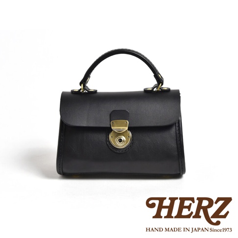 黑色皮革迷你手提包，配有金屬旋轉鎖扣和提把。