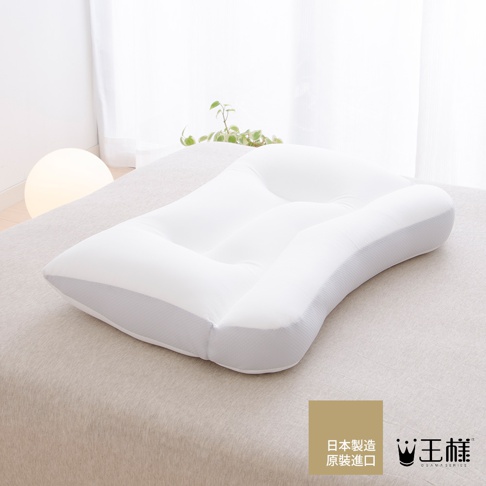 王樣の極夢枕，天絲 TENCEL 枕套，純白色枕芯，帶有灰色網格邊緣，枕頭表面有凹槽設計，放置於淺色床鋪上。