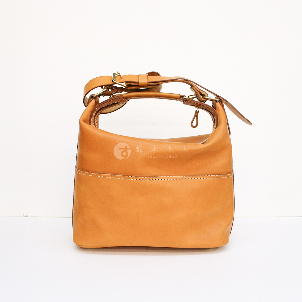 棕褐色皮革厚實單肩波士頓包，帶有可調節的皮質提把及肩帶，包身線條圓潤，正面有雙針縫線裝飾。