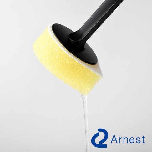 Arnest 品牌直角鍋專用清潔海綿，黃色海綿與白色部分組成，黑色手柄，海綿上有水滴下。