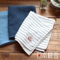 三條摺疊的紗布毛巾，其中兩條為素色，分別為淺藍色和深藍色，另一條為白色底帶有細緻黑色條紋，上面有一個紅色標籤。