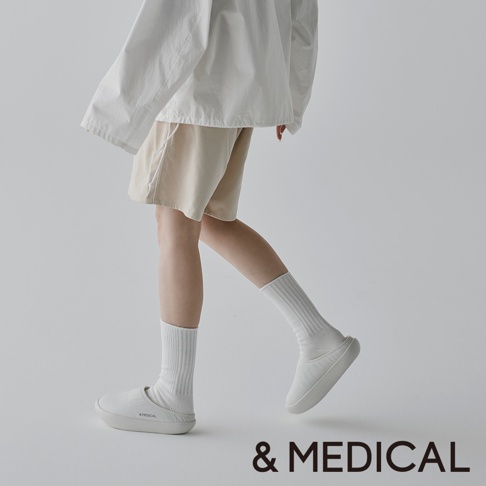 & MEDICAL 的白色休閒鞋搭配同色系襪子，展現簡約時尚的穿搭風格。
