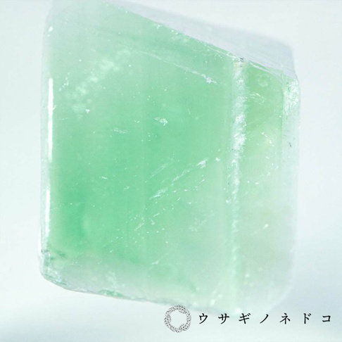Sola cube 礦石立方塊，為螢石材質，呈現半透明的淺綠色，立方體表面有細微的紋路與雜質，光線穿透時產生朦朧感。