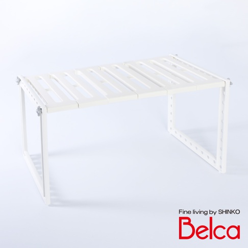 白色伸縮槽下單層站立收納架，採用塑膠材質，結構為可調節的兩層架，頂層為條狀鏤空設計，兩側支架有圓形孔洞，整體簡潔實用。