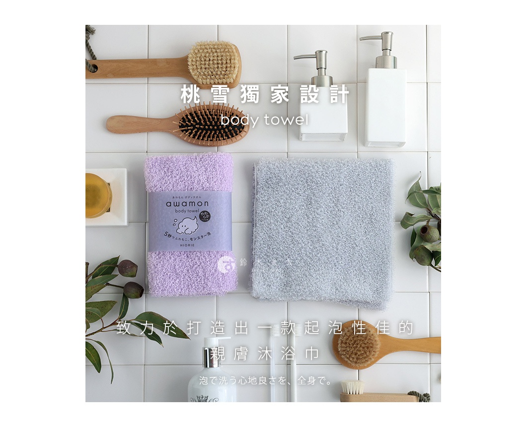 日本桃雪獨創怪物級綿柔起泡親膚沐浴巾，柔軟款，圖片展示了紫色和灰色浴巾，搭配木柄刷、香皂和按壓瓶，營造潔淨舒適的沐浴氛圍。