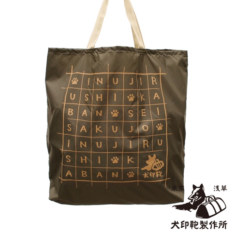 深棕色環保折疊收納購物袋，正面印有米色網格文字及腳印圖案，配有米色提把。