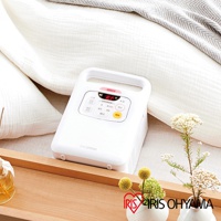 白色IRIS OHYAMA雙筒強力烘被機 FK-W1，機身方正，頂部有提把，面板上有數字顯示及多個功能按鍵，包括「開始」、「停止」、「模式」、「除菌」、「烘乾」等，放置於白色床鋪旁。