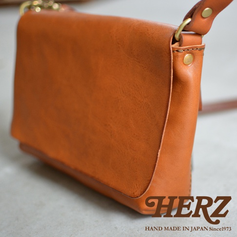HERZ 職人手作皮革隨身斜背包，採用橘棕色皮革，設計簡約，質感細緻，展現日式職人精神。