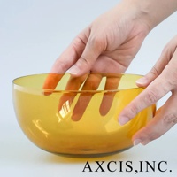 一隻手捧著琥珀色透明玻璃製成的 LAGOM 清透復古圓潤點心碗，碗身呈現圓潤曲線，表面光滑。