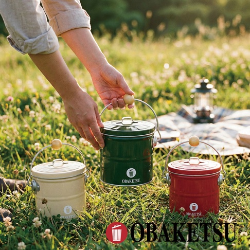 OBAKETSU 品牌手工製蚊香桶，綠色、米白色和紅色擺放在草地上，其中綠色蚊香桶由手拿著，背景有野餐墊和燈飾