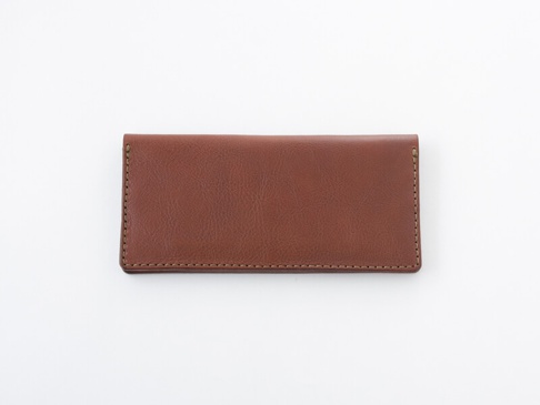 職人手作皮革簡約輕薄扁長夾，採用溫暖的棕色皮革，表面帶有細緻的紋理，邊緣以同色系線跡縫合，展現精緻工藝。