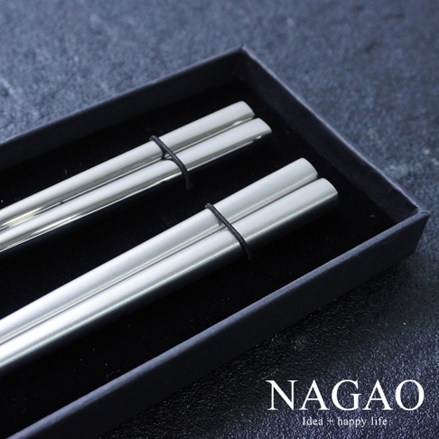 一組兩雙燕三條不鏽鋼筷，每雙長 22.3 公分，筷子呈現銀灰色，表面經過霧面處理，以黑色細繩固定於黑色禮盒中。