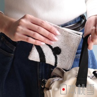 模式B： 一名女子將一條印有熊貓圖案的毛巾放入口袋，旁邊放著一個帆布包，包上印有「日本桃雪」的字樣。