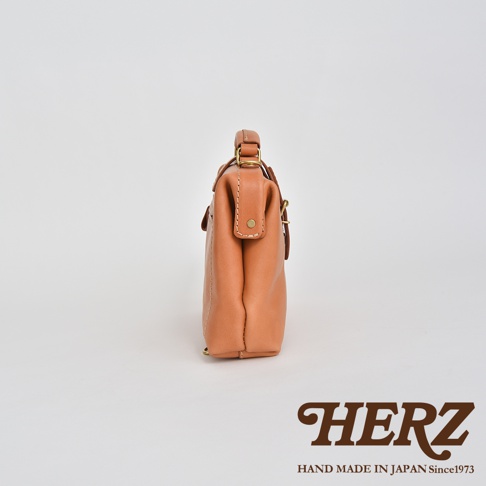 職人手作皮革迷你軟皮杜勒斯包，採用淺棕色柔軟皮革製成，帶有金色五金配件和精緻縫線。包款設計簡潔，適合日常攜帶。