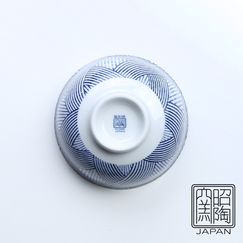 藍染縞格子飯碗，白色陶瓷碗身，外側繪有藍色線條交織的縞格子圖案，碗底中央有藍色印記，標示「昭和窯」與「SHOWA JAPAN」。