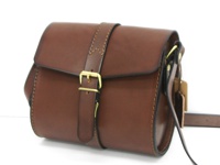 棕色皮革製成的手提單肩包，有金色金屬皮扣和可調節肩帶，側面和邊緣有縫線細節。