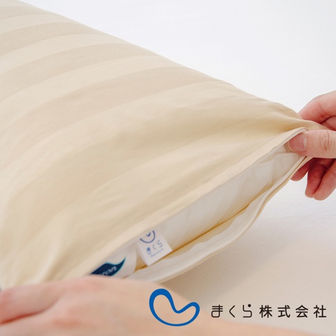 特製柔彈午睡枕，米白色純棉條紋枕套，拉鍊半開，露出白色內裡。
