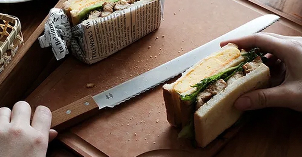 morinoki 麵包刀，不鏽鋼刀刃搭配木質手柄，刀刃上有鋸齒狀邊緣與樹木圖案，刀身部分有細微顆粒感。