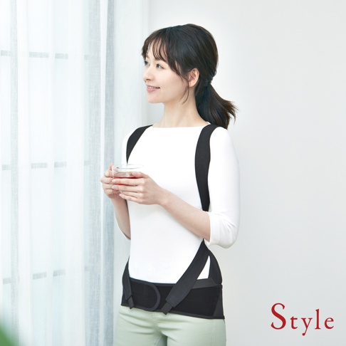 一名女性穿著黑色 BX Pro 美姿調整背帶，其肩帶從後方延伸至腰部，並有固定腰帶。