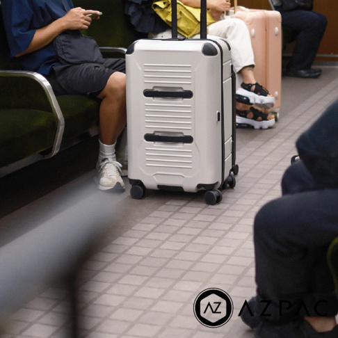 模式B： 一名旅客坐在火車座位上，前方擺放著一個白色行李箱，旁邊還有另一位旅客。