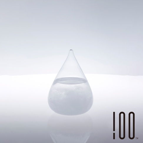 透明玻璃製成的 Tempo Drop 天氣瓶，外觀呈水滴狀，瓶內裝有部分透明液體和白色結晶沉澱物，瓶身底部有反光效果。