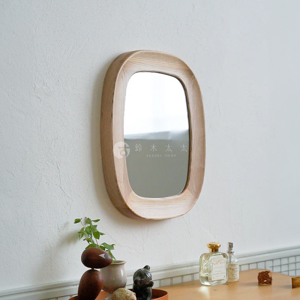 橢圓形木框壁掛鏡，木框呈現自然原木色澤，紋理清晰。鏡面光滑，反射出環境光線。