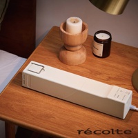 recolte 奶油白烘被機 RFK-1 放在木質床頭櫃上，旁邊有木製燭台和黑色罐裝香氛蠟燭